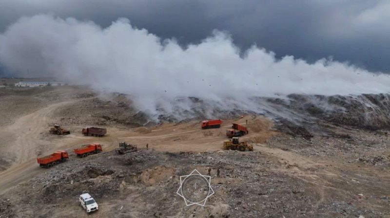Пожарные едят прямо на месте пожара, чтобы не терять время при тушении горящей свалки близ Алматы