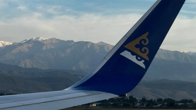 Крыло борта Air Astana на фоне гор