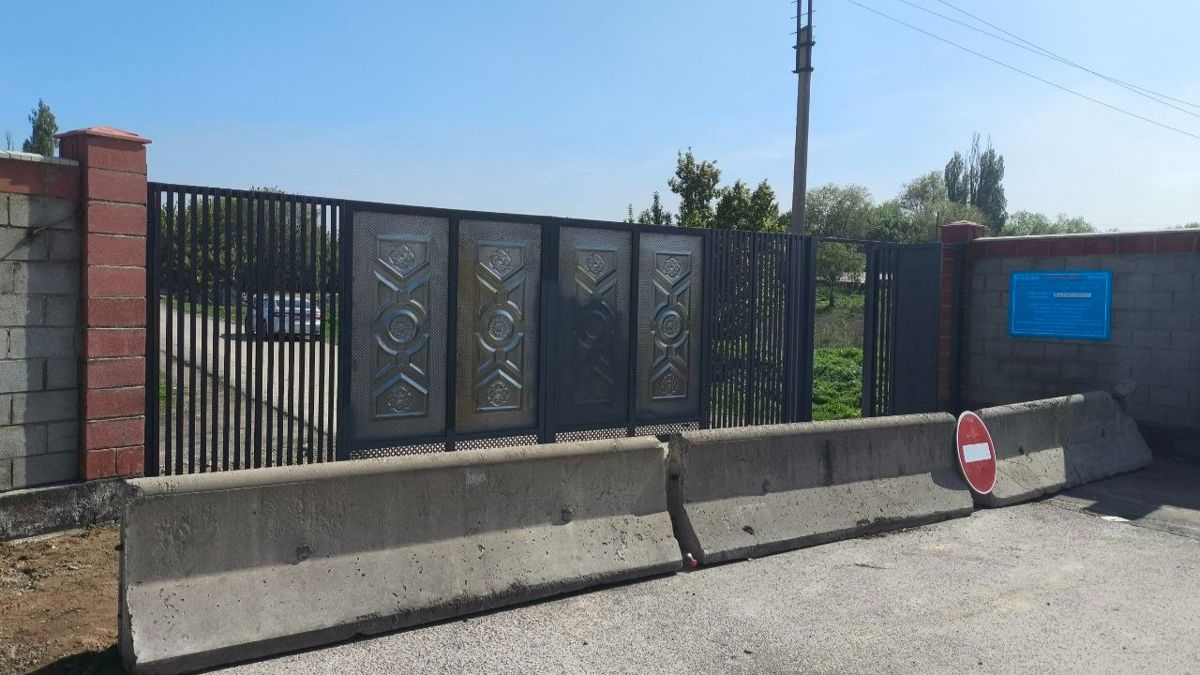 Ворота и бетонное ограждение на другой стороне кладбища