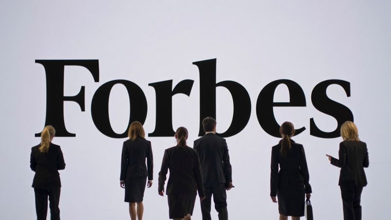 Люди на фоне логотипа Forbes