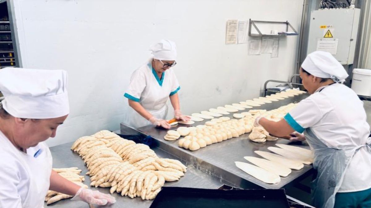Работницы хлебобулочного предприятия замешивают тесто и формуют продукцию