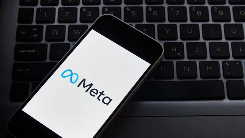 Телефон с надписью Мета лежит на клавиатуре ноутбука