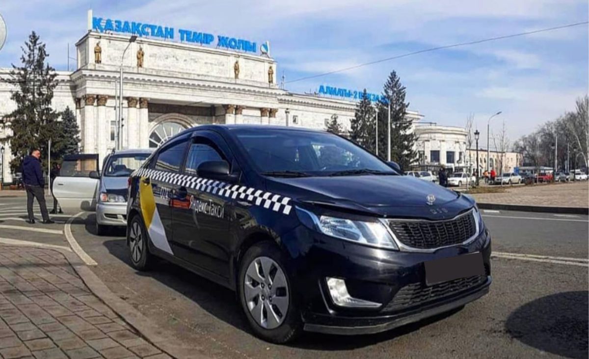 Чёрная машина марки KIA, припаркованная вдоль улицы
