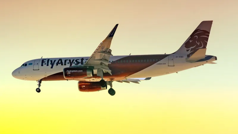 Пассажирский самолёт FlyArystan в фирменной ливрее во время полёта с выпущенным шасси