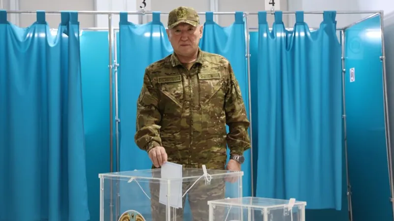 Министр обороны Казахстана Даурен Косанов опускает бюллетень в урну на избирательном участке в Астане