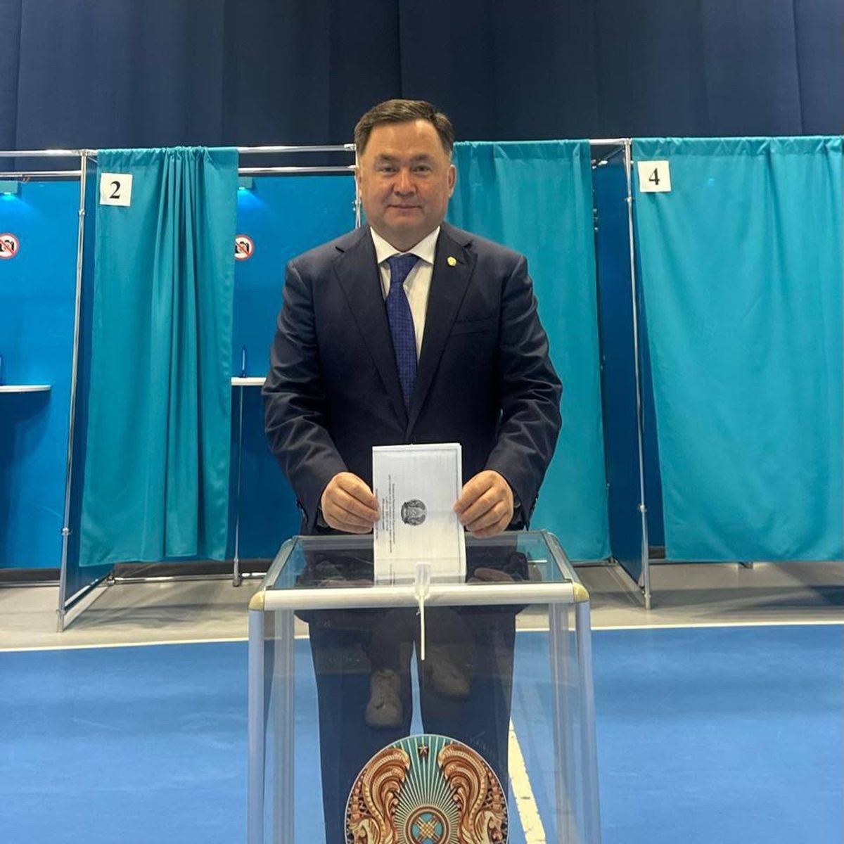 Председатель Верховного суда Асламбек Мергалиев опускает бюллетень в урну на избирательном участке № 169 в Астане
