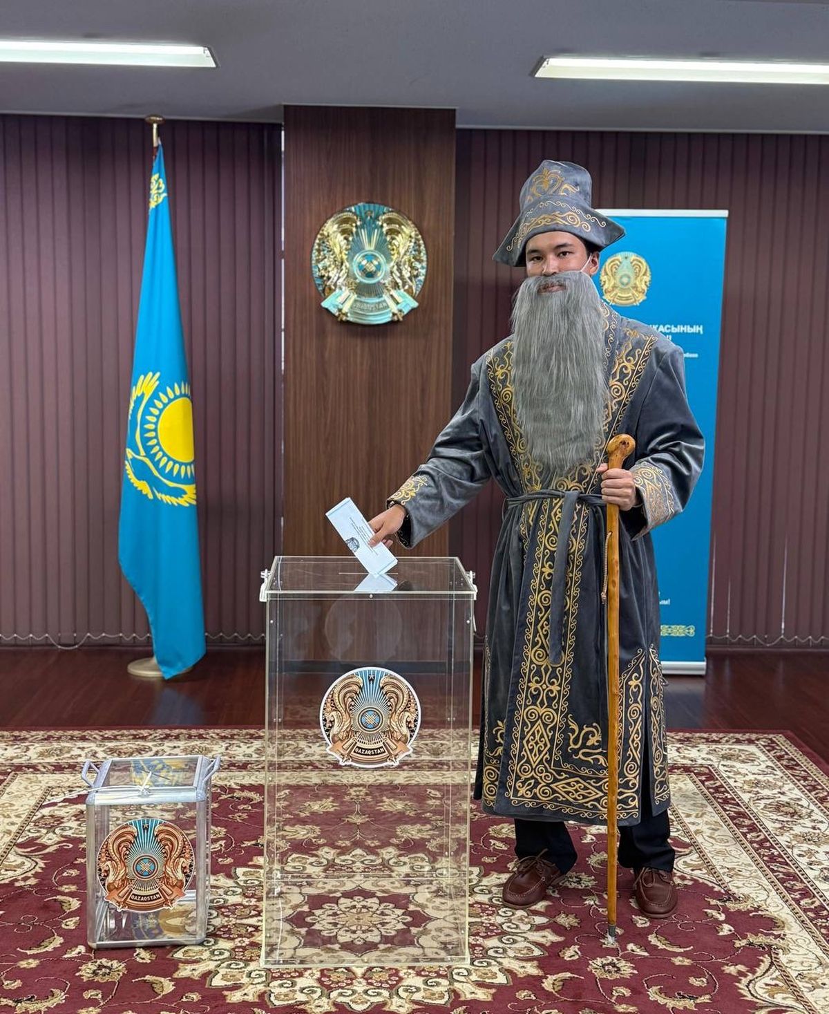 Казахстанец Алишер Азимбаев в образе бия опускает бюллетень в урну на избирательном участке в Токио