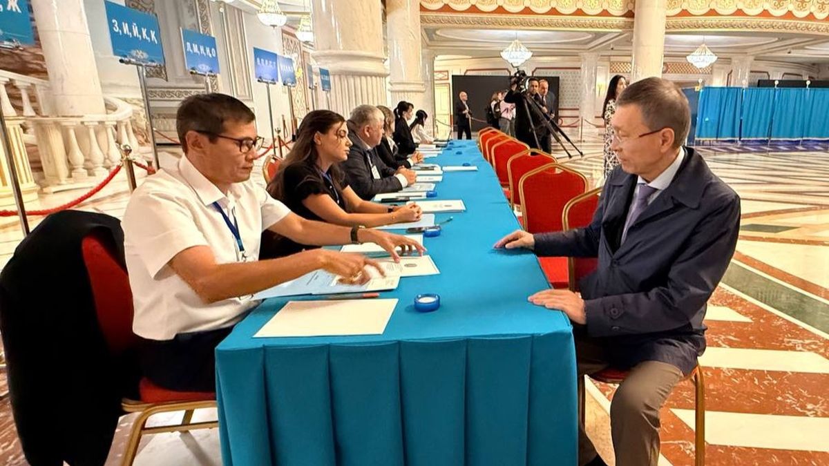 Председатель Центральной избирательной комиссии Нурлан Абдиров получает бюллетень перед голосованием на выборах депутатов курултая в Астане