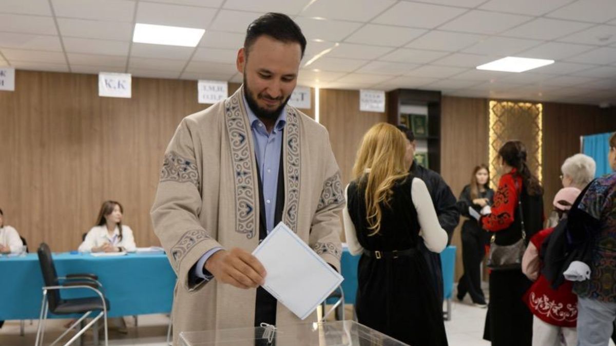 Председатель партии Respublica Айдарбек Ходжаназаров опускает бюллетень в урну на избирательном участке в школе № 101 в Астане