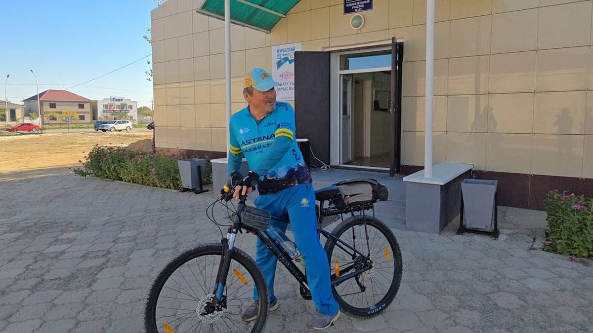 Велопутешественник из Мангистауской области Раббим Борашев с велосипедом возле избирательного участка после голосования на выборах депутатов курултая
