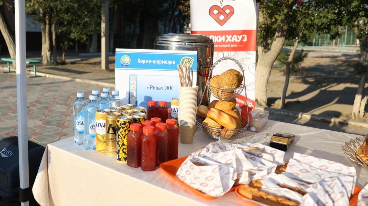 Стол с продуктами и выпечкой на продовольственной ярмарке, организованной в школе № 2 имени Жумекена Нажимеденова в Атырау в день выборов
