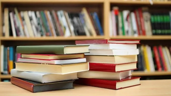 Две стопки книг на фоне полок с книгами