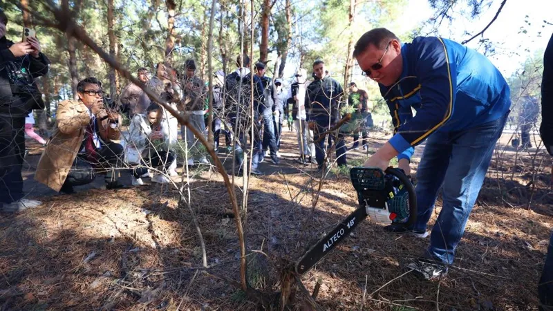 Кумар Аксакалов поливает дерево