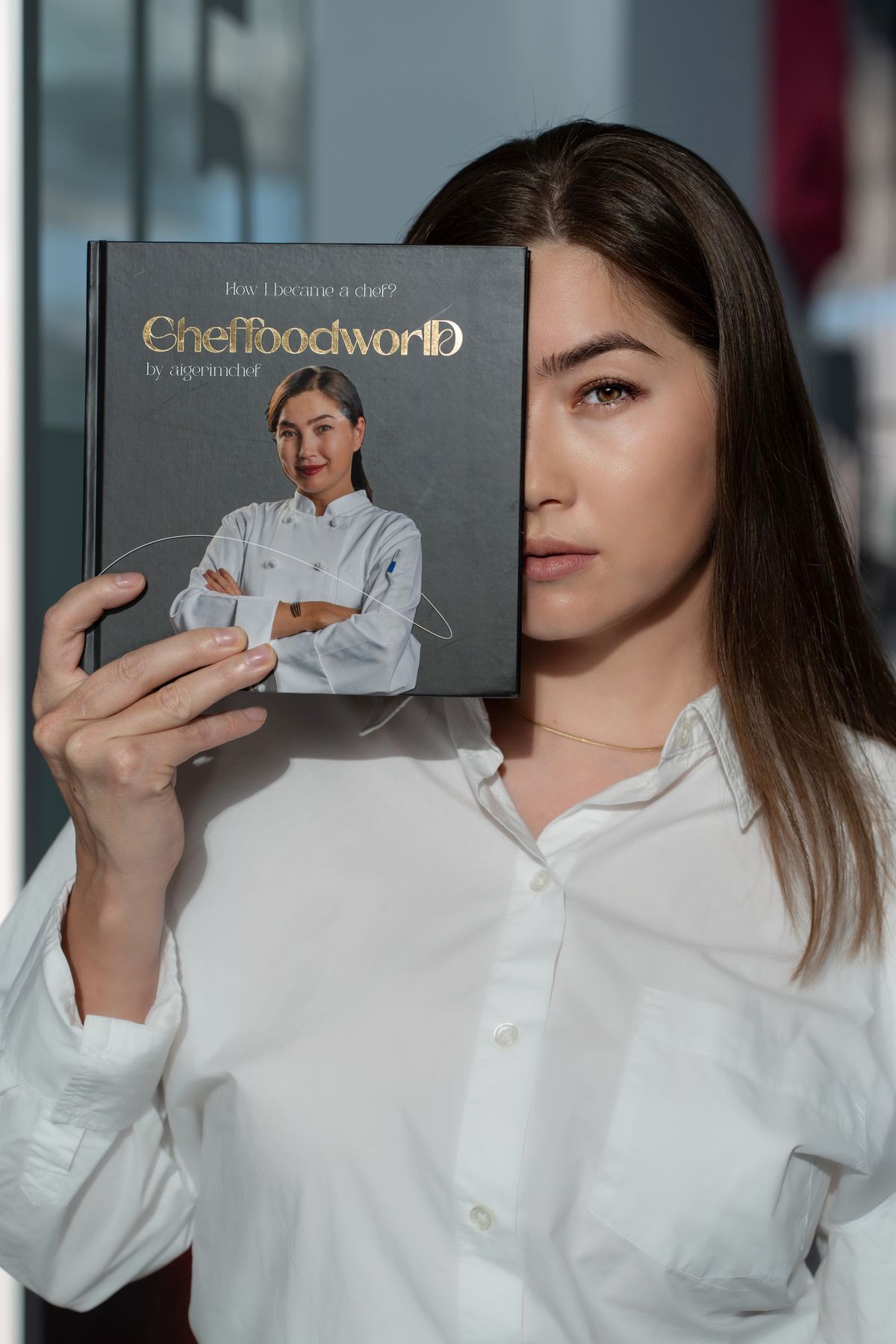 Айгерим Айтбаева позирует со своей кулинарной книгой