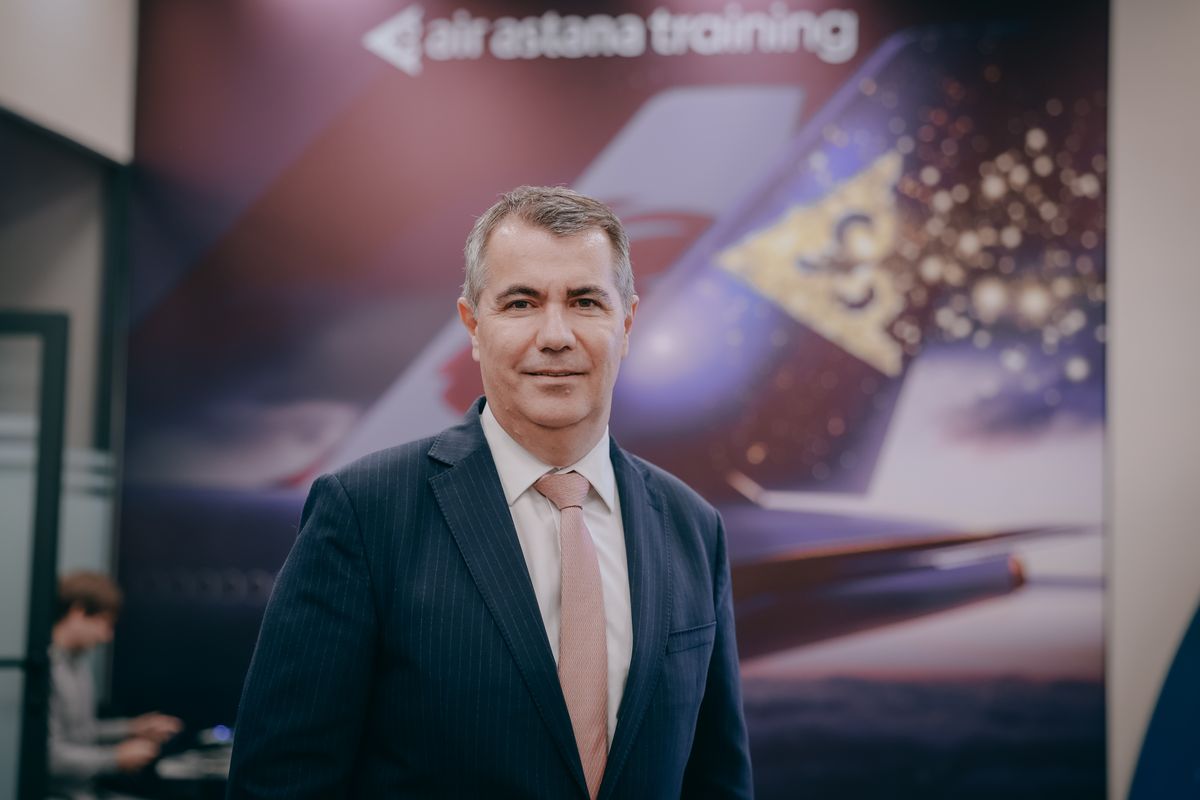 Ибрахим Жанлыел, главный исполнительный директор группы Air Astana, на фоне баннера Air Astana Training