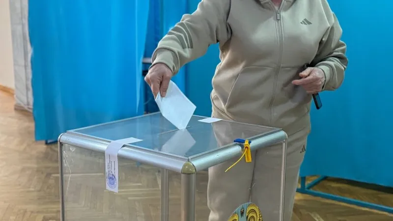 Избиратель бросает бюллетень в урну